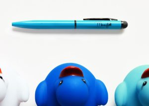 Bolígrafo mini color azul junto a patitos de plástico