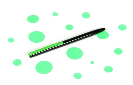 bolígrafo metálico sobre puntos verdes